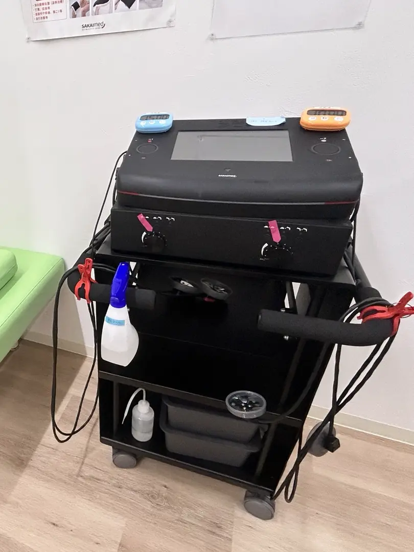 リハビリ室内の治療機器とベッドの一部